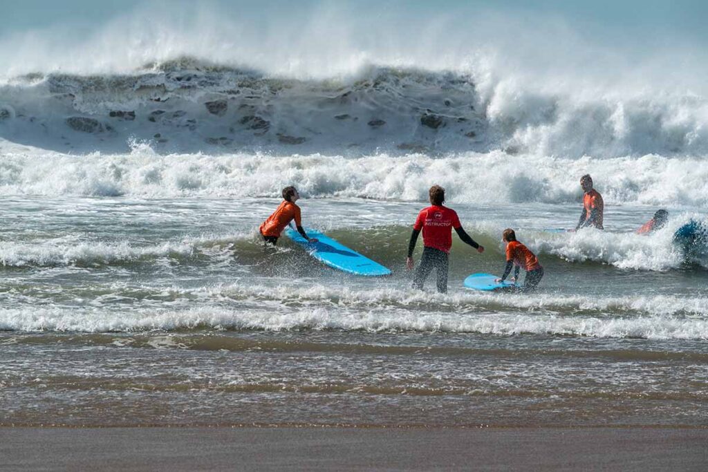 Surf school instructor and students in powerful surf at Croyde Bay, North Devon.